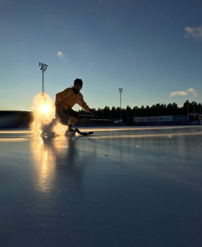 Elev spelar bandy på blank isrink.