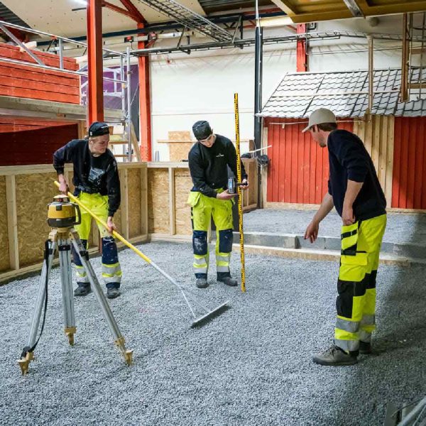 Tre elever mäter på inriktningen anläggning.