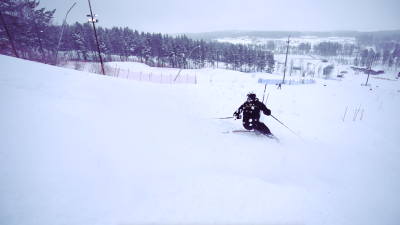 Person åker slalom i en skidbacke.