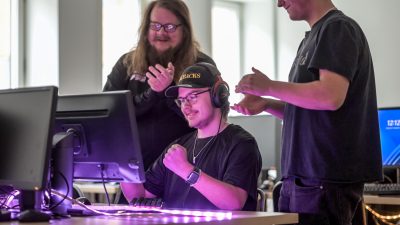E-sportelev hejas på av lagkamrat och coach.