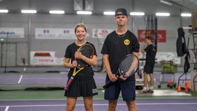 Två tenniselever håller sina racket.