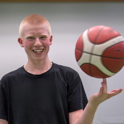 Elev snurrar basketboll på fingret.