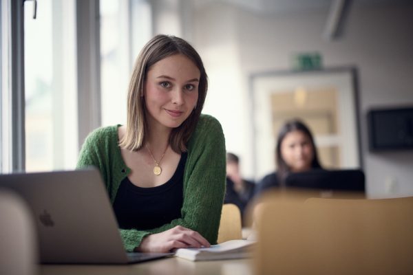 Elev på samhällsvetenskap som sitter i klassrummet med sin dator.