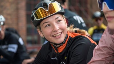 Tjej med hjälm och cykelglasögon på huvudet.